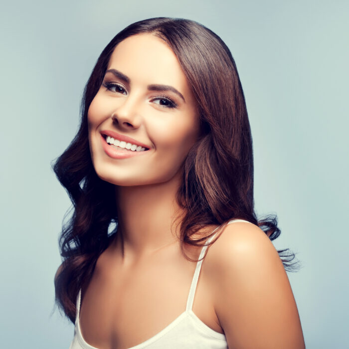 portrait of beautiful smiling young woman in white tank top clothing